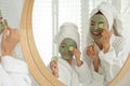 Young mother and her daughter with masks near mirror Royalty Free Stock Photo