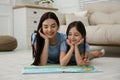 Young mother and her daughter reading book at home Royalty Free Stock Photo