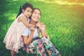 Young mother and her daughter relaxing sitting on green grass Royalty Free Stock Photo