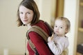 Young mother and her girl in a baby carrier Royalty Free Stock Photo