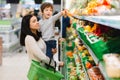 Young mother with her little baby boy at the supermarket. Healthy eating concept Royalty Free Stock Photo