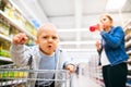 Young mother with her little baby boy at the supermarket. Royalty Free Stock Photo