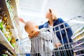 Young mother with her little baby boy at the supermarket. Royalty Free Stock Photo