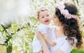 Young mother and her little baby relaxing in a spring orchard Royalty Free Stock Photo