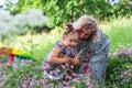 A young mother and her little daughter are having fun happy on a green flower meadow . Royalty Free Stock Photo