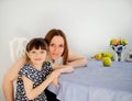 Young mother with her little daughter in kitchen