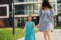 Young mother with her little daughter walking near the buildings Royalty Free Stock Photo