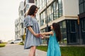 Young mother with her little daughter walking near the buildings Royalty Free Stock Photo