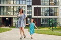 Young mother with her little daughter walking near the buildings Royalty Free Stock Photo