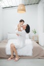 Young mother with her little girl are relaxing and playing in the bed at the weekend together. Kid at home concept Royalty Free Stock Photo