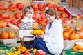 Young mother and her little son playing on pumpkin patch farm. Royalty Free Stock Photo