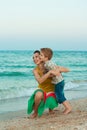 Young mother with her son having fun on the beach Royalty Free Stock Photo