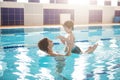 Young mother and her son having fun in a swimming pool. Healthy family mother teaching baby swimming pool Royalty Free Stock Photo