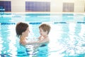 Young mother and her son having fun in a swimming pool. Healthy family mother teaching baby swimming pool Royalty Free Stock Photo