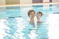 Young mother and her son having fun in a swimming pool. Healthy family mother teaching baby swimming pool Royalty Free Stock Photo