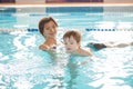 Young mother and her son having fun in a swimming pool. Healthy family mother teaching baby swimming pool Royalty Free Stock Photo