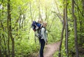 A young mother and her son take a hike together in the mountains on a beautiful summer evening. Cute young baby son riding on moms Royalty Free Stock Photo