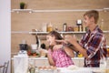 Young mother and her teenage daughhter playing with flour while making delicious food.