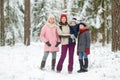 Young mother and her three kids having fun outdoors. Two young girls and their baby boy sibling on winter day. Kids with large age