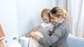 Young mother with her toddler boy flushing water in toilet after using it Royalty Free Stock Photo