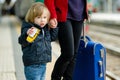 Young mother and her toddler son on a railway station. Mom and little child waiting for a train on a platform. Family with a Royalty Free Stock Photo