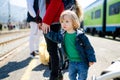 Young mother and her toddler son on a railway station. Mom and little child waiting for a train on a platform. Family ready to Royalty Free Stock Photo