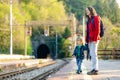 Young mother and her toddler son on a railway station. Mom and little child waiting for a train on a platform. Family ready to Royalty Free Stock Photo