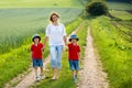 Young mother with her two children in a spring blooming field on Royalty Free Stock Photo