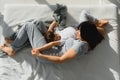 Young mother with her 4 years old little son dressed in pajamas are relaxing and playing in the bed at the weekend together, lazy Royalty Free Stock Photo