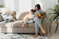 Young mother with her 4 years old little son dressed in pajamas are relaxing and playing in the bed at the weekend together, lazy Royalty Free Stock Photo