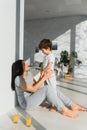 Young mother with her 4 years old little son dressed in pajamas are relaxing and playing in the bedroom at the weekend together, Royalty Free Stock Photo