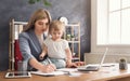 Young mother holding baby while writing notes