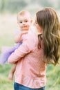 Young mother holding daughter in her arms. Beautiful Mother And Baby outdoors. Nature. Beauty Mum and her Child playing Royalty Free Stock Photo