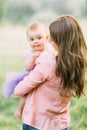 Young mother holding daughter in her arms. Beautiful Mother And Baby outdoors. Nature. Beauty Mum and her Child playing Royalty Free Stock Photo