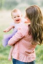 Young mother holding daughter in her arms. Beautiful Mother And Baby outdoors. Nature. Beauty Mum and her Child playing Royalty Free Stock Photo