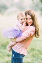 Young mother holding daughter in her arms. Beautiful Mother And Baby outdoors. Nature. Beauty Mum and her Child playing Royalty Free Stock Photo