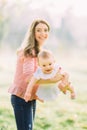 Young mother holding daughter in her arms. Beautiful Mother And Baby outdoors. Nature. Beauty Mum and her Child playing Royalty Free Stock Photo