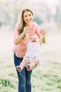 Young mother holding daughter in her arms. Beautiful Mother And Baby outdoors. Nature. Beauty Mum and her Child playing Royalty Free Stock Photo