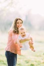 Young mother holding daughter in her arms. Beautiful Mother And Baby outdoors. Nature. Beauty Mum and her Child playing Royalty Free Stock Photo