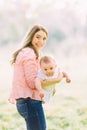 Young mother holding daughter in her arms. Beautiful Mother And Baby outdoors. Nature. Beauty Mum and her Child playing Royalty Free Stock Photo