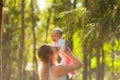 Young mother holding daughter in her arms. mom kisses and plays with daughter in the summer. Happy family in the park Royalty Free Stock Photo