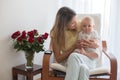 Young mother holding her baby boy, playing with him, sitting in