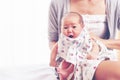 Young mother holding her newborn baby girl, one week daughter