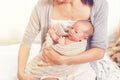 Young mother holding her newborn baby girl, one week daughter