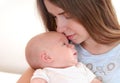 Young mother holding her newborn child and kiss him Royalty Free Stock Photo