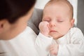 Young mother holding her newborn child. Mom nursing baby. Woman and new born boy relax in a white bedroom. Royalty Free Stock Photo