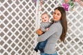 Young mother holding her newborn child. Woman and baby boy relax in a white bedroom. Nursery interior. Family at home Royalty Free Stock Photo