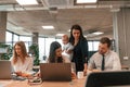 Young mother is holding her son. Infant baby is in the office where group of people are working together Royalty Free Stock Photo