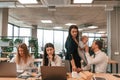 Young mother is holding her son. Infant baby is in the office where group of people are working together Royalty Free Stock Photo