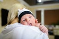 Young mother holds baby on hands, presses to shoulder and lulls